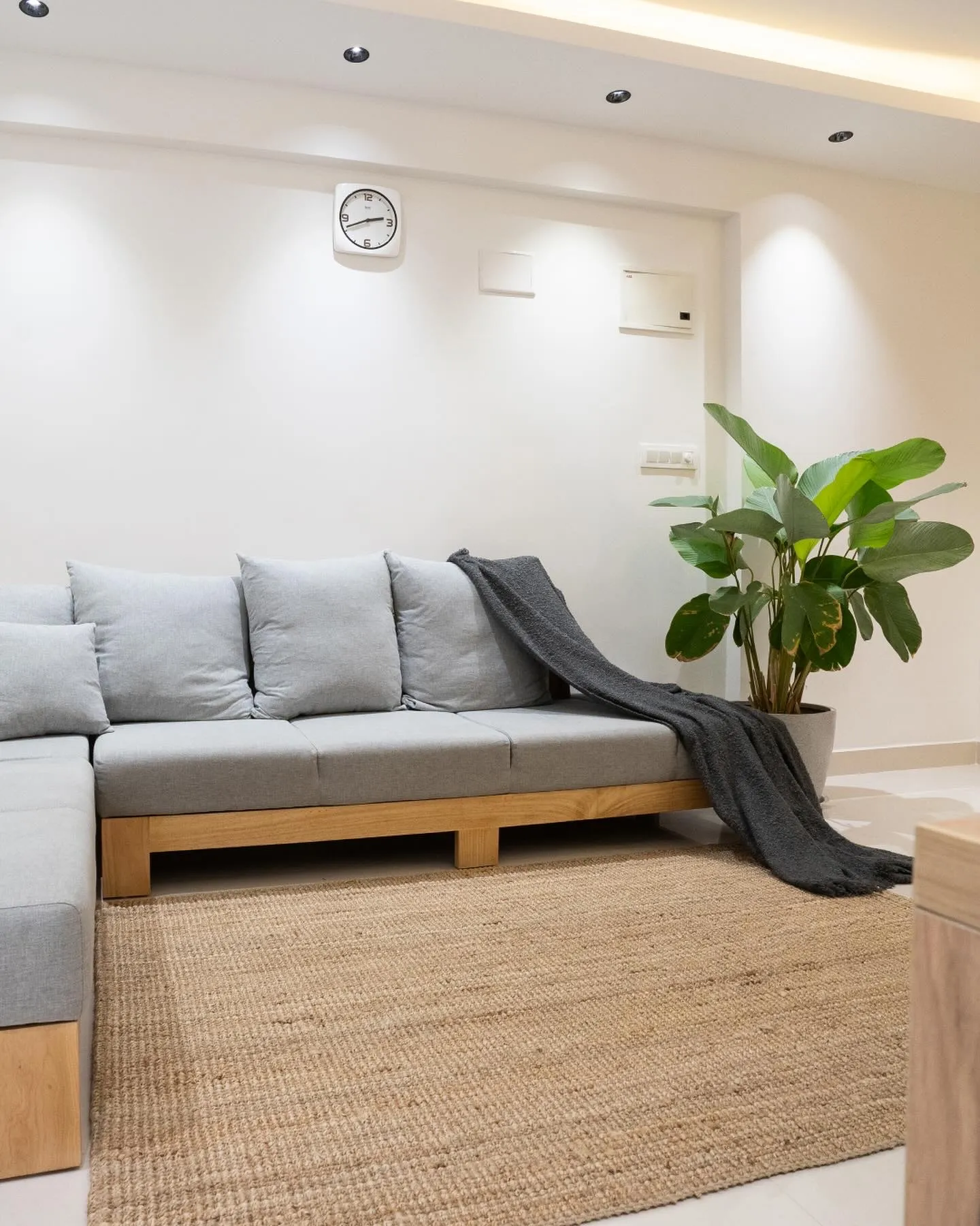 Living room with grey oak-frame sofa and jute rug — The Aakar